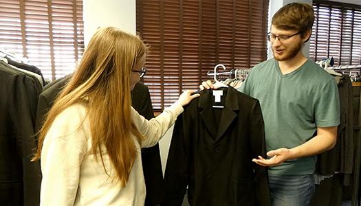 a student worker helps another student find professional attire